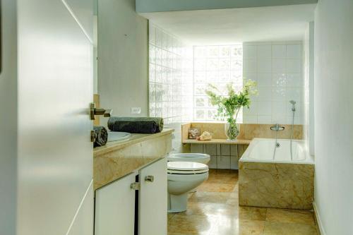 a bathroom with a toilet and a tub and a sink at Villa La Cala Playa by Villa Plus in La Cala de Mijas
