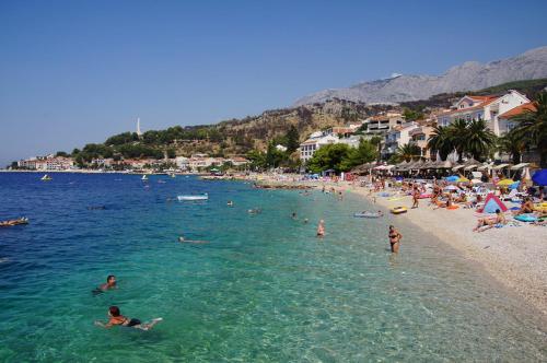 a group of people in the water at a beach at Apartments Raos Podgora in Podgora