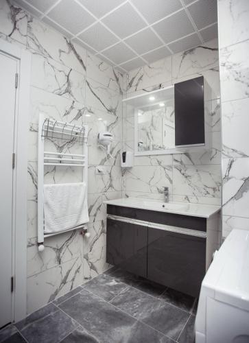 a bathroom with marble walls and a sink and a mirror at Gazioğlu Residence in Trabzon