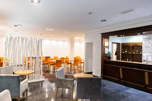 a restaurant with tables and chairs and a bar at Hotel Serrano in Madrid