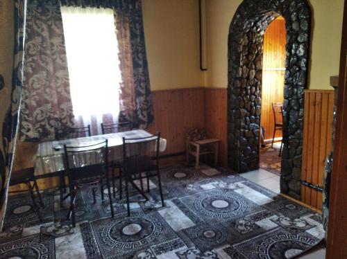 ポドボホツにあるРадугаのテーブルと椅子、窓が備わる客室です。
