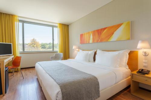 a hotel room with a large bed and a television at HF Fenix Garden in Lisbon