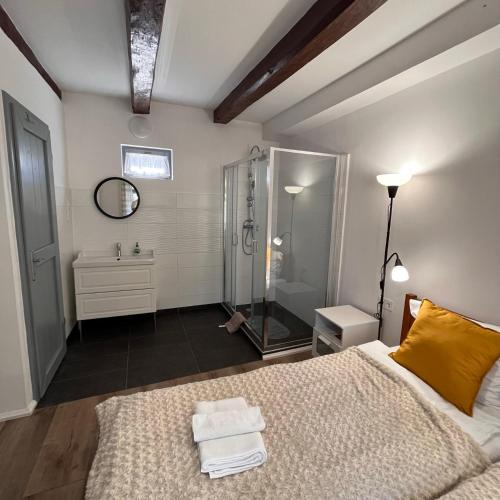 a bedroom with a shower and a bed with towels at Vitamin K73 Vendégház in Boldogkőváralja