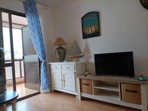 een woonkamer met een flatscreen-tv op een kast bij Apartamento en Cala de Finestrat in Cala de Finestrat