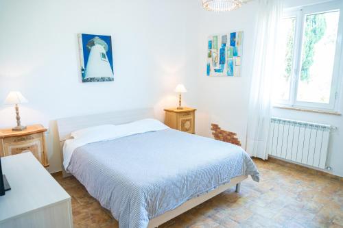 um quarto branco com uma cama e 2 janelas em Relais Bellavista Tuscany em Suvereto