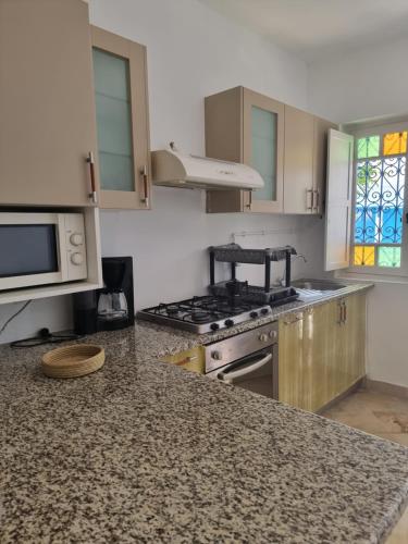 a kitchen with a stove and a counter top at Cosy 1bdr, with a terasse in heart of Sidibou in Sidi Bou Saïd