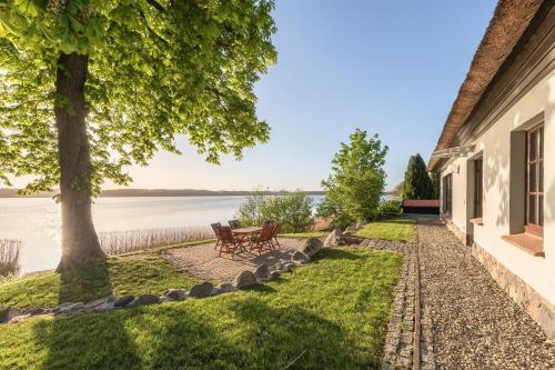 a walkway next to a house with a view of the water at Haus am See in Torgelow am See