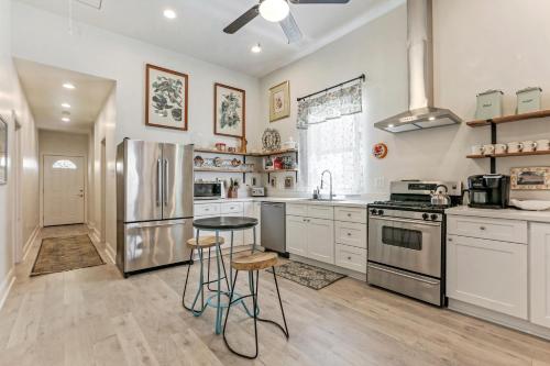 a kitchen with white cabinets and stainless steel appliances at Renovated Historic 4BR House Near Magazine St & Uptown in New Orleans