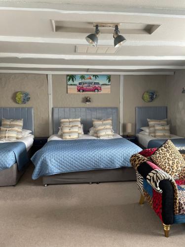 a bedroom with two beds and a couch at Molesworth Arms in Wadebridge