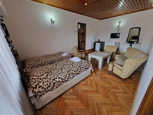 a bedroom with a bed and a chair and a table at CATTALEYA in Batumi
