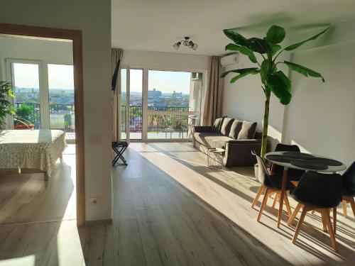 uma sala de estar com um sofá e uma mesa em Summer Haven- self check-in, parking, netflix, terrace, near mall em Oradea