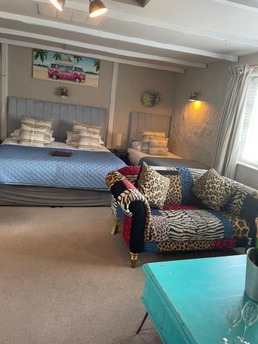 a woman sitting on a bed in a living room at Molesworth Arms in Wadebridge