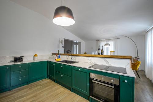 - une cuisine avec des placards verts et un évier dans l'établissement Villa Casale by Villa Plus, à Ostuni