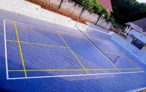 a blue tennis court with yellow lines on it at RAIN DROPS PREMIUM VILLAS - Athirappilly in Athirappilly
