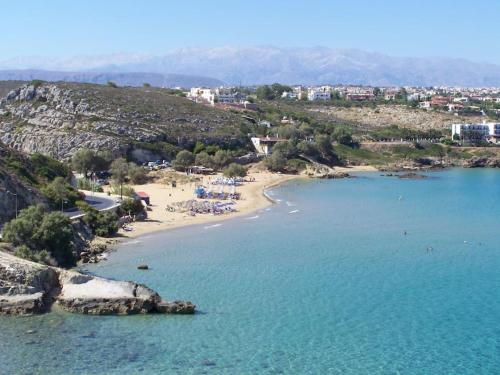 a beach with a group of people in the water at Manolo s olive farm, apartment with seaview in Chania Town