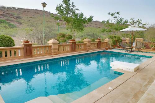 a swimming pool with a wooden fence around it at The Almond Tree in Jodhpur
