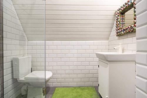 La salle de bains blanche est pourvue de toilettes et d'un lavabo. dans l'établissement Piricske Pihenőház, à Ciceu