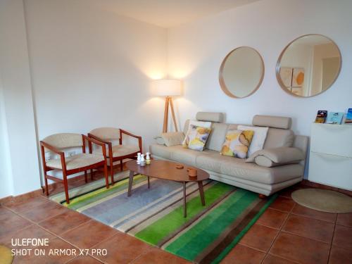 uma sala de estar com um sofá, uma mesa e cadeiras em Facing the ocean em Santa Maria de Guia de Gran Canaria