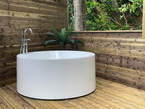 a white bath tub sitting on a wooden deck at リバウッドリゾート in Mori