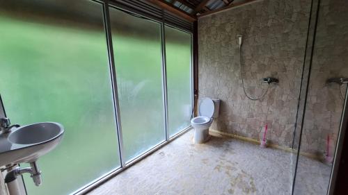 ein Badezimmer mit Dusche, Toilette und Waschbecken in der Unterkunft Bukit Lawang Hill Resort in Bukit Lawang