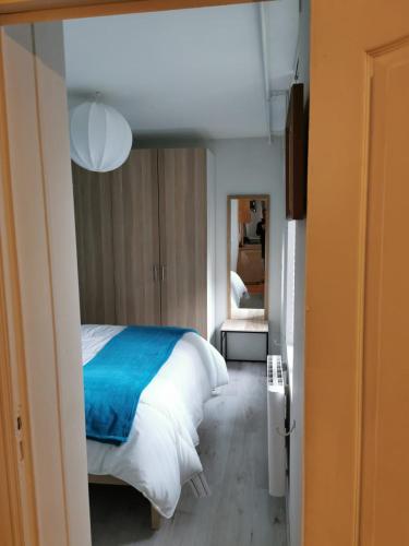 une chambre avec un lit avec une couverture bleue dans l'établissement Appartement de charme, à Honfleur