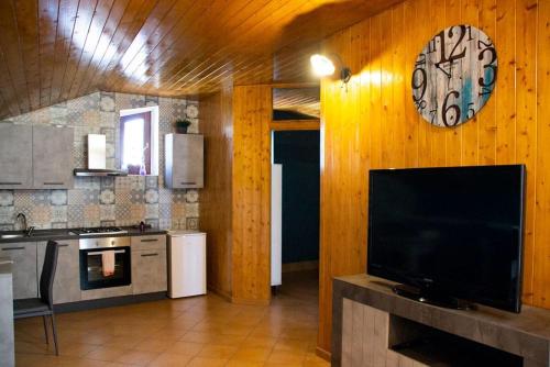 a kitchen with a large clock on a wooden wall at Original Sicily in Santa Venerina
