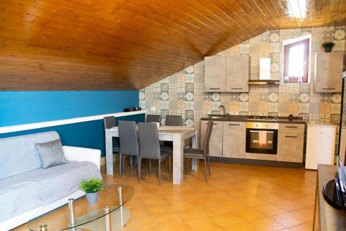 a kitchen and living room with a table and a couch at Original Sicily in Santa Venerina