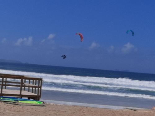 three kites flying over the ocean on a beach at FiloApartment in Peniche