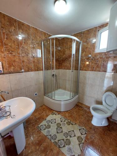y baño con ducha, aseo y lavamanos. en Apartments South, en Ulcinj