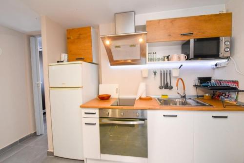 a kitchen with a white refrigerator and a sink at Grcka Reni Greece Beach Penthaus 3 in Nea Kalikratia