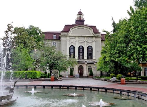 a building with a fountain in front of a building at Sunflower Apartment City Center in Plovdiv