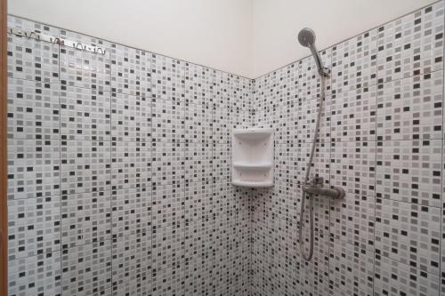 a bathroom with a shower with a soap dispenser on the wall at KoolKost Syariah @ Cempaka Putih (Minimum Stay 6 Nights) in Jakarta