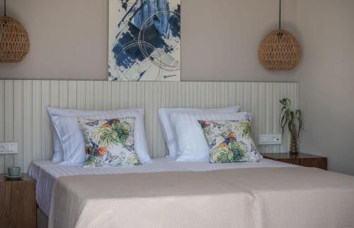 a bedroom with a bed with white sheets and pillows at Delight Luxury Villa - Contemporary Elegance & Tranquility, by ZanteWize in Zakynthos Town