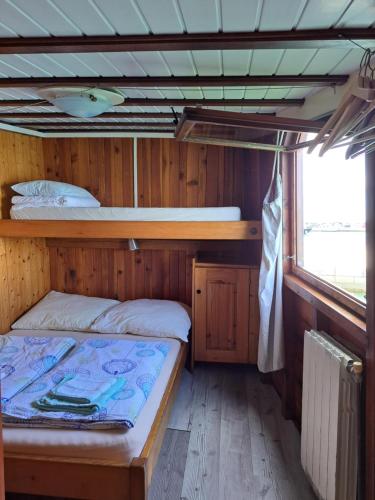 1 dormitorio con 1 cama en una cabaña de madera en Boat & breakfast en Umag