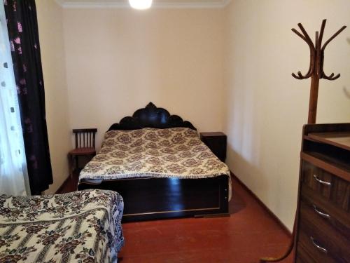 a bedroom with a bed and a dresser at chelo in Ambrolauri
