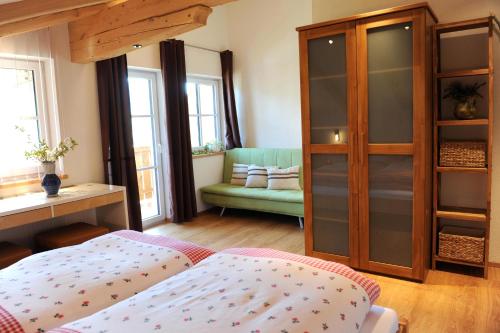a bedroom with a bed and a cabinet and a couch at Appartements - Haus Sieberer in Brixen im Thale