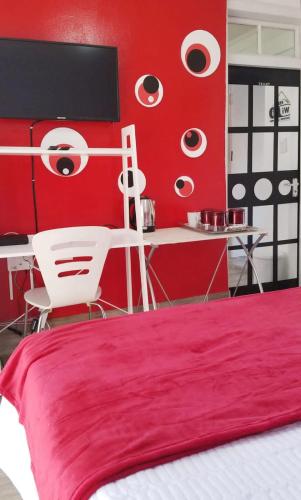 a red bedroom with a white bed and a desk at The Link on Bonsai in Kempton Park