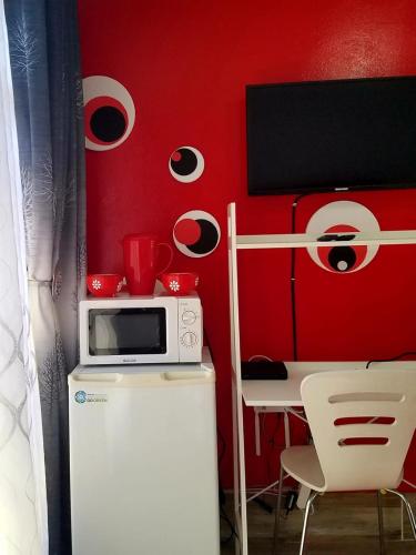 a kitchen with a microwave and a table with chairs at The Link on Bonsai in Kempton Park