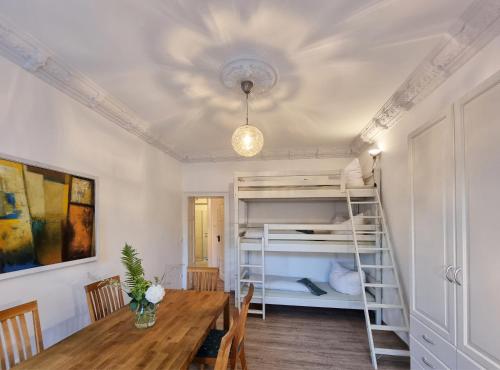 a dining room with a table and a bunk bed at Hostel Lollis Homestay Dresden in Dresden