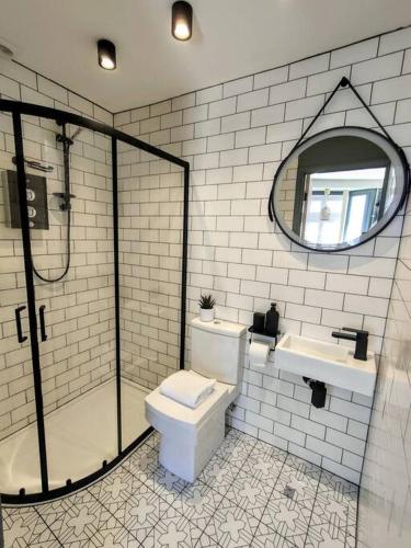 a bathroom with a toilet and a sink and a mirror at One of a Kind Luxury Studio Stay in Penzance in Penzance