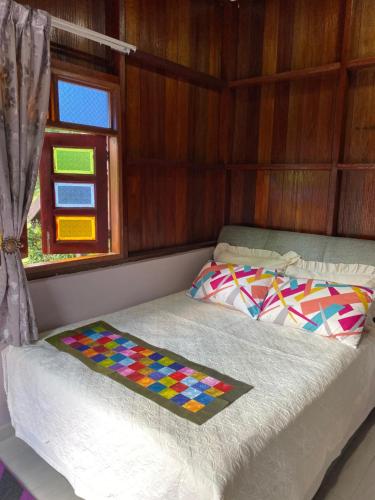 a bed with a colorful blanket on it in a room at Teratak Sekayu ( Room Stay ) in Kuala Kerau