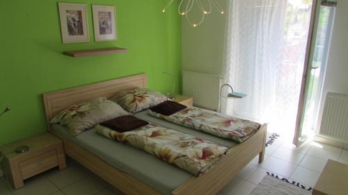 een slaapkamer met een bed met groene muren bij apartmány LUHA in Luhačovice