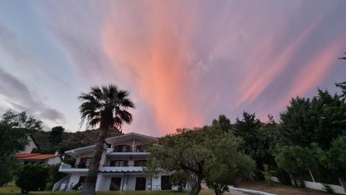 a rainbow in the sky over a house at Katerina's Garden Mola Kaliva in Mola Kalyva