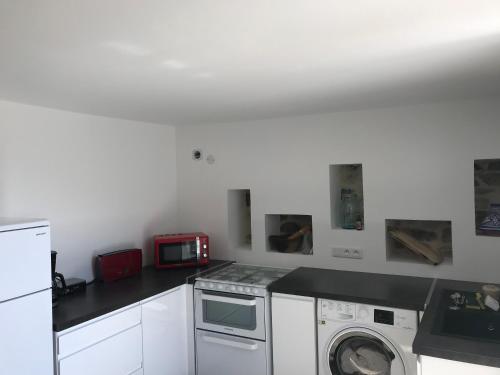 une cuisine avec un lave-linge et un micro-ondes dans l'établissement Menton Mignon 2p bucolique vue mer campagne, à Menton