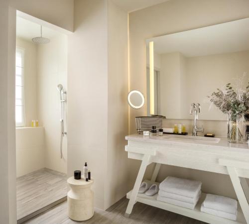 a bathroom with a sink and a mirror at Le Grand Pavillon Chantilly in Chantilly