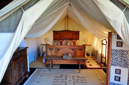 a bedroom with a bed in a tent at Guillerin Caravan and Glamping in Sornac