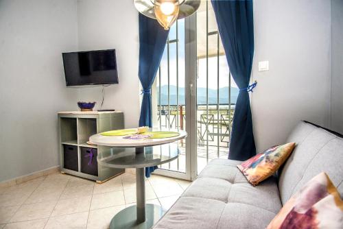 - un salon avec un canapé et une table dans l'établissement Xenia Ionis luxury apartments, à Lixouri