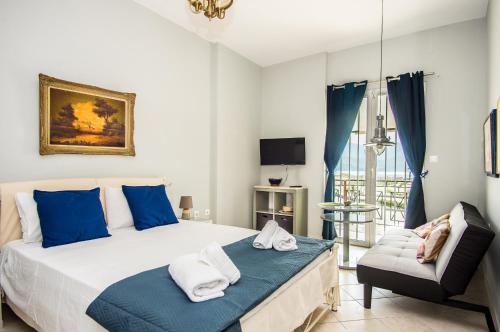 a bedroom with a large bed and a chair at Xenia Ionis luxury apartments in Lixouri