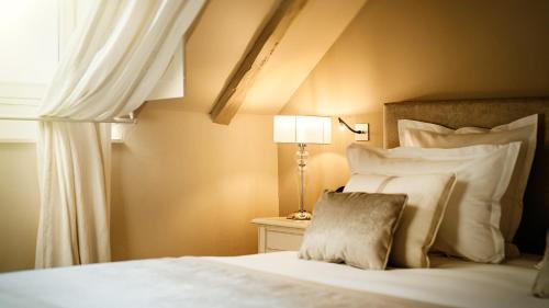 a bedroom with a bed with a lamp and a window at Abbaye De Villeneuve in Les Sorinières
