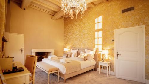 a bedroom with a large bed and a chandelier at Abbaye De Villeneuve in Les Sorinières